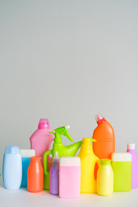 Bottles of chemical cleaning products arranged on a table