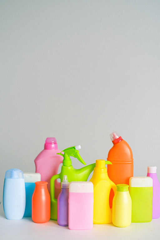 Bottles of chemical cleaning products arranged on a table