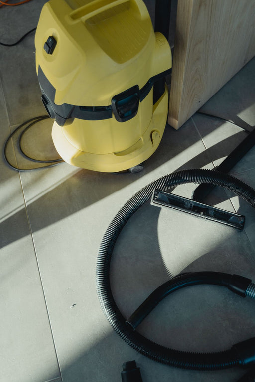 Commercial vacuum cleaner with hose on tiled floor