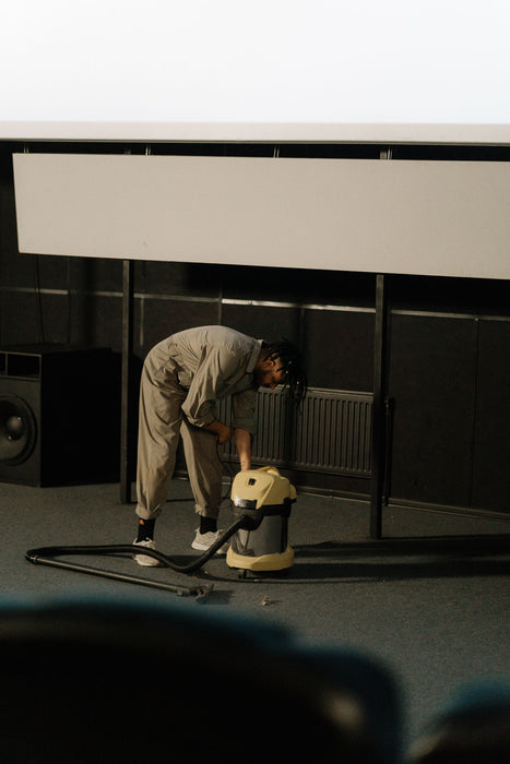 Worker using commercial cleaning equipment in a large indoor space