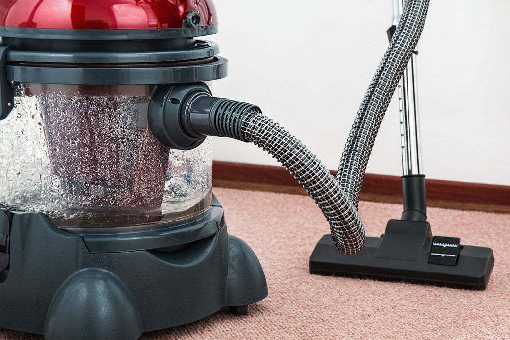 Portable carpet spot extractor vacuum on carpet floor
