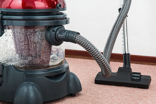 Portable carpet spot extractor vacuum on carpet floor